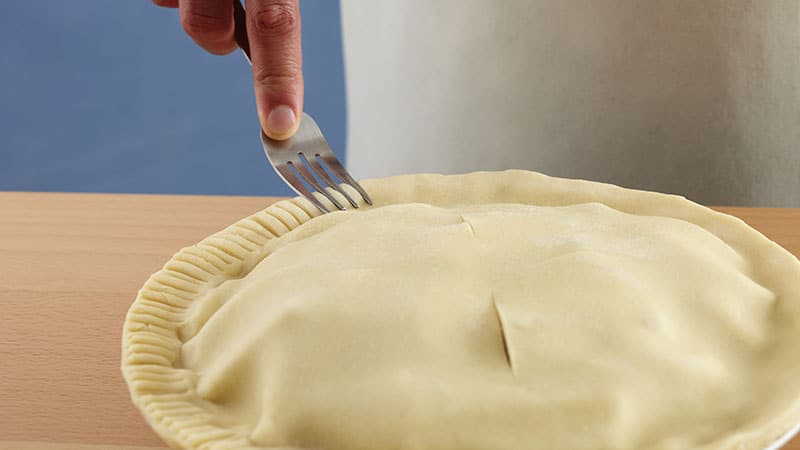 Dip a fork tine in flour, then press the fork into the crust edge, facing inward, without pressing through the pastry. 